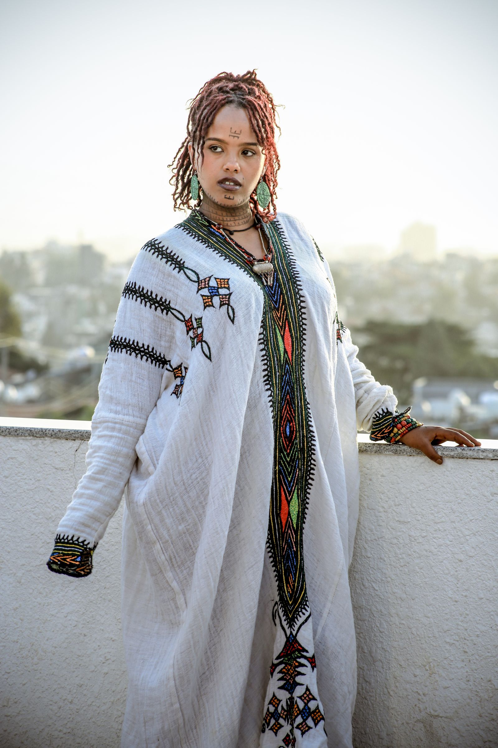 Woman in a white habesha kemis with gold and green tibeb